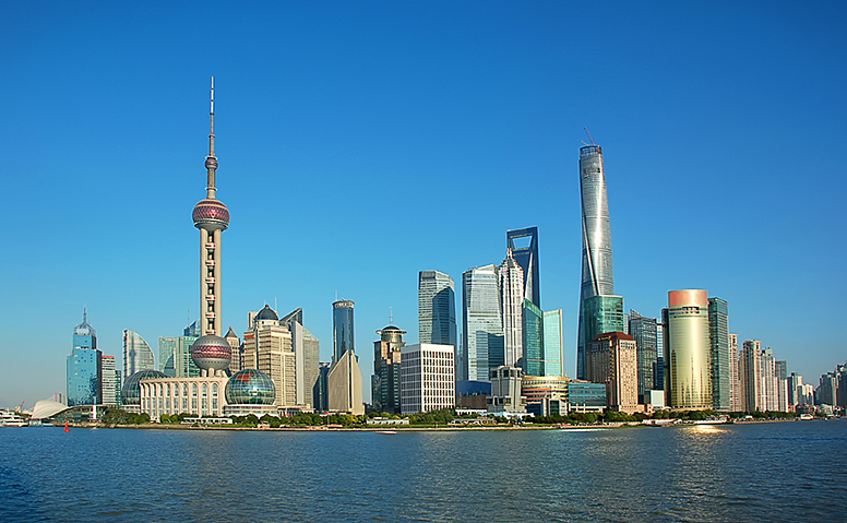 China: Shanghai skyline with skyscrapers and satellite tower under a blue sky