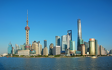 China: Shanghai skyline with skyscrapers and satellite tower under a blue sky