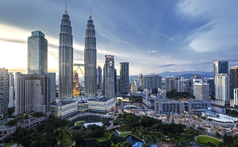 Malaysia: Panorama of Kuala Lumpur, impressive skyscrapers in front of a green park