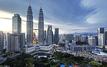 Malaysia: Panorama of Kuala Lumpur, impressive skyscrapers in front of a green park