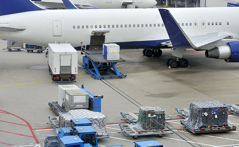 Air cargo: An aeroplane stands on a landing field and is loaded with cargo Air cargo: An aeroplane stands on a landing field and is loaded with cargo
